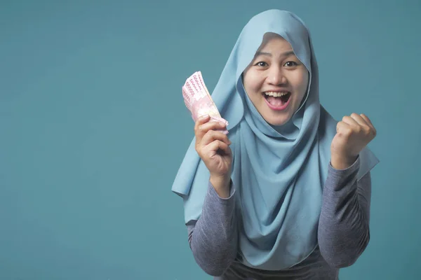 Indonésia muçulmano mulher segurando rupias dinheiro — Fotografia de Stock