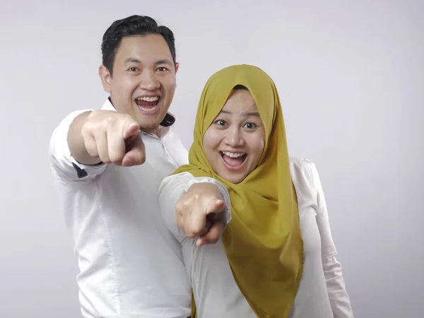 Szczęśliwa azjatycka muzułmańska para uśmiecha się i wskazuje na kamerę — Zdjęcie stockowe