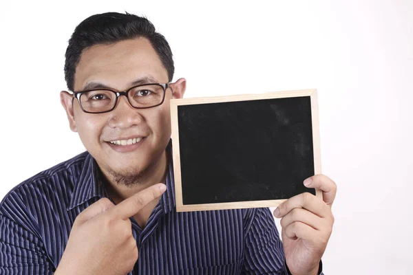 Joven asiático hombre sonriendo y presentando vacío copia espacio blackboa — Foto de Stock