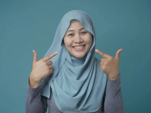 Selbstbewusste muslimische Frau lächelt und zeigt auf sich selbst — Stockfoto