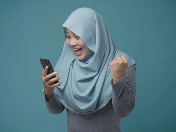 Junge muslimische Frau erhält gute Nachrichten auf ihrem Handy — Stockfoto