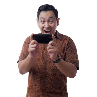 Mutlu genç Asya adam oyun oyunlar üzerinde tablet akıllı telefon