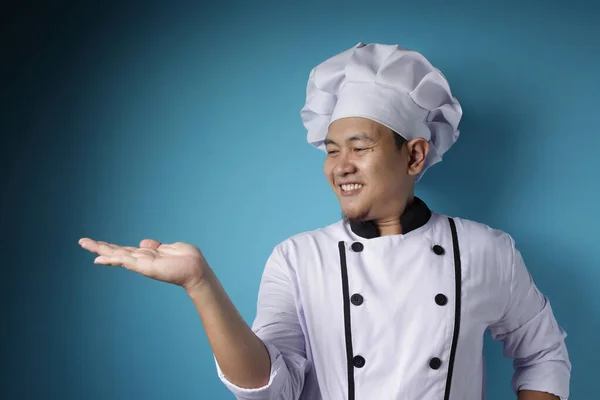 Gelukkig lachende aziatische chef wijzen presenteren iets op zijn em — Stockfoto