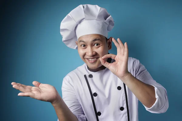 Heureux sourire asiatique chef pointant présenter quelque chose sur son em — Photo