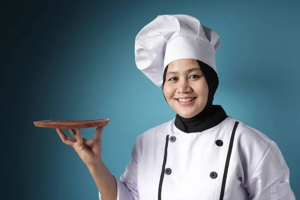 Aziatische vrouwelijke chef-kok toont lege houten plaat, presenteren iets — Stockfoto