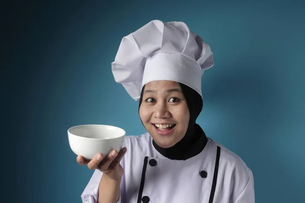 Aziatische vrouwelijke chef-kok toont lege witte schaal, presenteren iets, — Stockfoto
