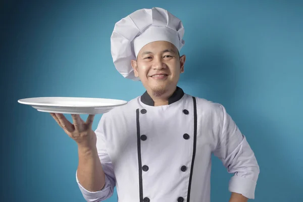 Aziatisch man chef-kok toont lege witte plaat, presenteren iets, C — Stockfoto