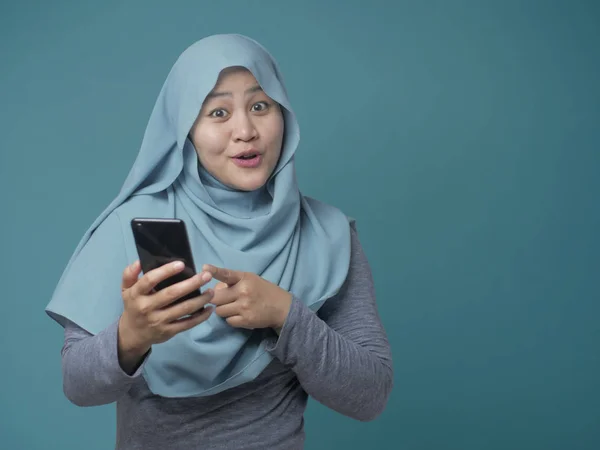 幸せなイスラム教徒の女性は彼女のスマートフォンを指して — ストック写真