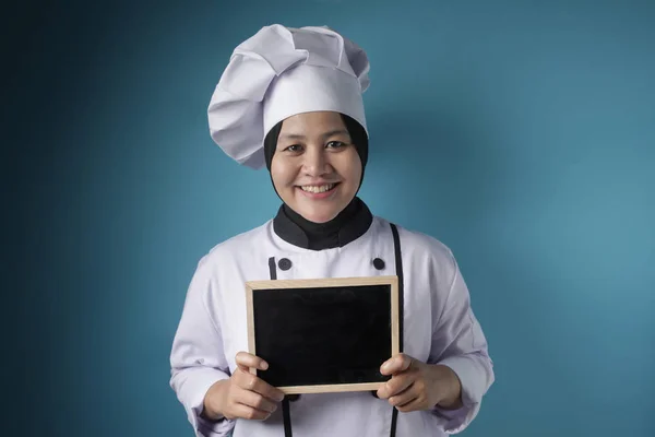 Aziatisch vrouwelijk chef-kok toont lege schoolbord, presenteren blank Writi — Stockfoto