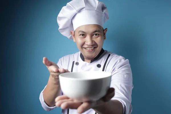 Asiatische männliche Koch zeigt leere weiße Schüssel, präsentiert etwas, co — Stockfoto