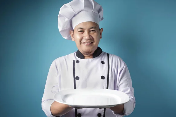 Asian Male Chef Shows Empty White Plate, Presenting Something, C — Stock Photo, Image