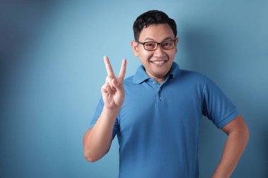 Genç adam Iki sayı veya barış Işareti jest gösterir