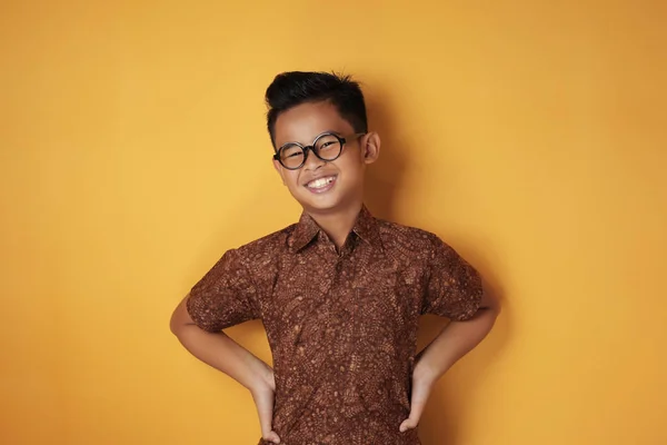 Smart asiatisk pojke tittar på kameran och ler — Stockfoto