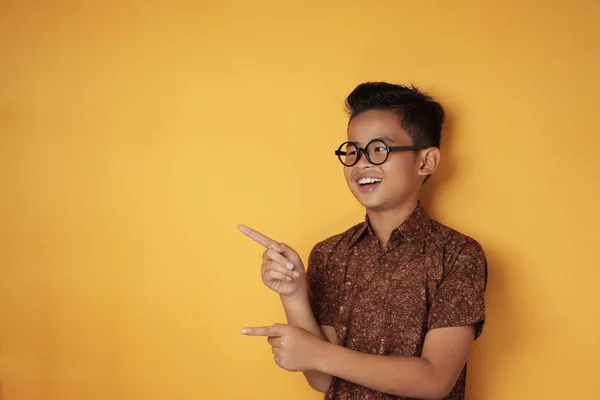 Aziatische jongen wijzend naar de zijkant met kopieerruimte — Stockfoto