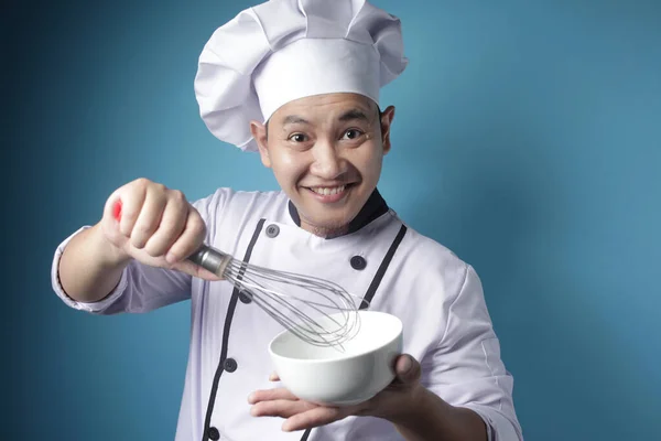 Asiatique mâle chef mélange ingrédient dans bol avec fouet — Photo