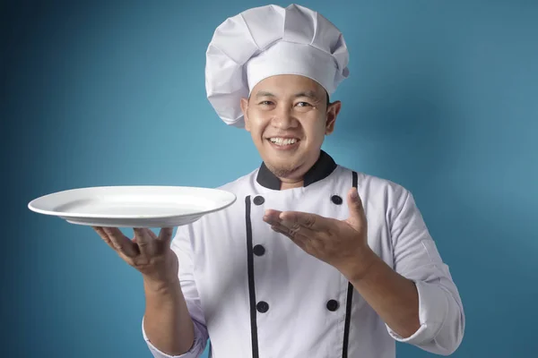 Asian Male Chef Shows Empty White Plate, Presenting Something, C — Stock Photo, Image