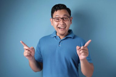 Genç adam iki parmağını havaya kaldırıyor, düşünüyor ve yukarı bakıyor, Havi