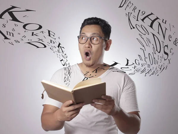 Hombre feliz sonriendo mientras lee el libro — Foto de Stock