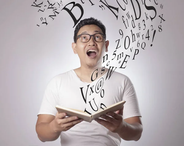 Hombre feliz sonriendo mientras lee el libro — Foto de Stock