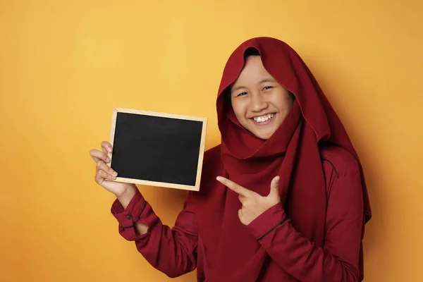 Intelligente asiatico musulmano adolescente ragazza sorridente a fotocamera e mostrando em — Foto Stock