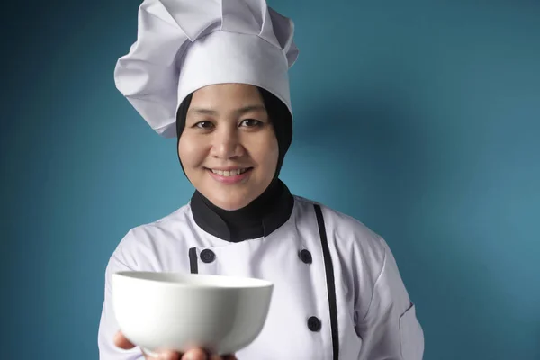 Aziatische vrouwelijke chef-kok toont lege witte schaal, presenteren iets, — Stockfoto