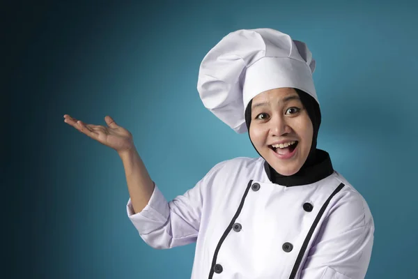Asiática hembra chef apuntando algo en su lado, presentando som —  Fotos de Stock