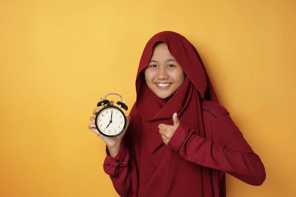 持有时钟和微笑的亚洲穆斯林少女 — 图库照片