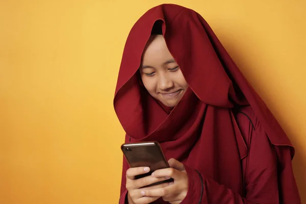 Ευτυχισμένη μουσουλμάνα έφηβος κορίτσι χαμογελώντας όταν συνομιλίας μηνυμάτων στο τηλέφωνο — Φωτογραφία Αρχείου