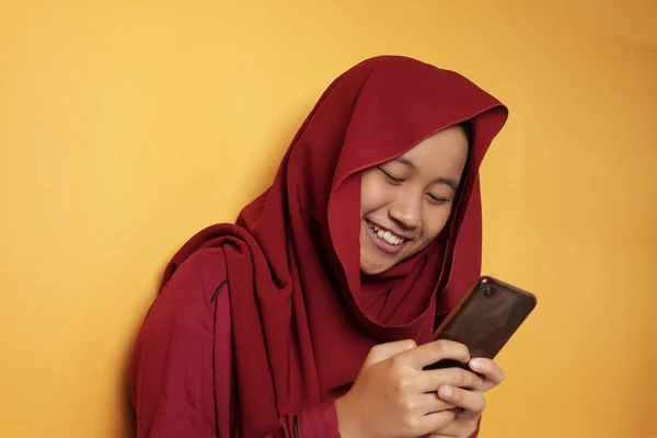 Boldog muszlim tini lány mosolygós Amikor Chat üzenetküldés telefonon — Stock Fotó