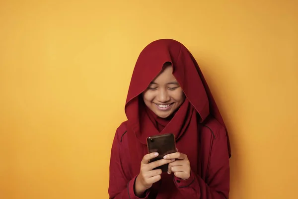 Felice musulmana adolescente ragazza sorridente quando chat messaggistica sul telefono — Foto Stock