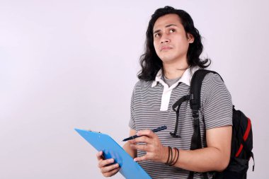 Asyalı üniversite öğrencisi elinde bir dosya tutuyor ve düşünüyor.