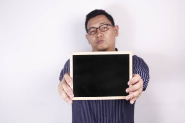 Adam sinirli ifadeyle boş karatahta gösteriyor