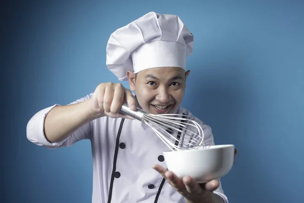 Asiatique mâle chef mélange ingrédient dans bol avec fouet — Photo