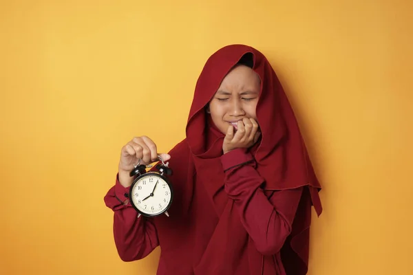Молодая девушка-азиатка-мусульманка, обеспокоенная временем — стоковое фото