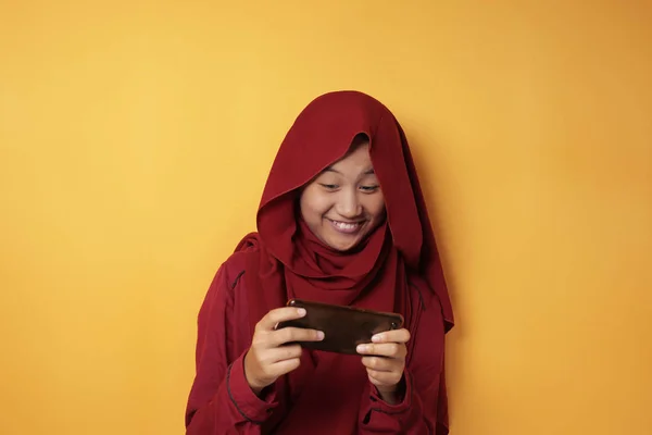 Asiático muçulmano adolescente menina joga jogos online no telefone — Fotografia de Stock