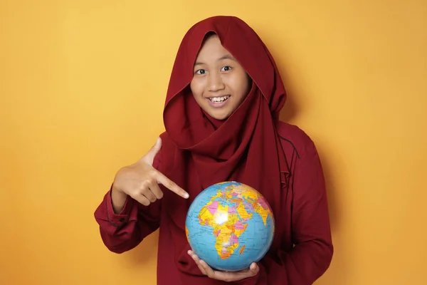 Asiático musulmán adolescente chica sonriendo mientras sostiene tierra globo —  Fotos de Stock