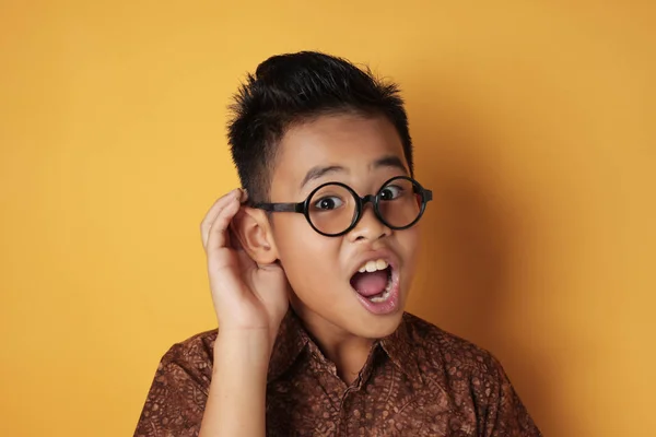 Pequeño asiático chico tratar de escuchar cuidadosamente — Foto de Stock