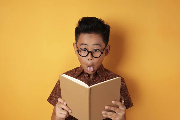 Divertido asiático estudiante chico impactado al leer libro — Foto de Stock