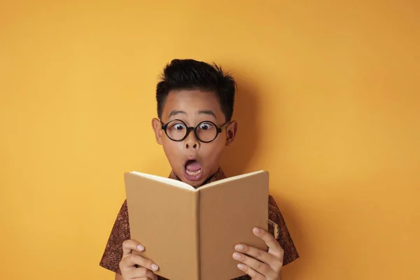 Divertente asiatico studente ragazzo scioccato quando lettura libro — Foto Stock