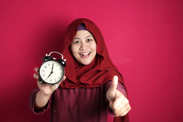 Ung affärskvinna ler medan du håller en klocka — Stockfoto