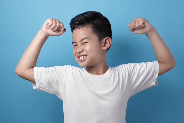 Fuerte sano asiático chico muestra su músculo — Foto de Stock