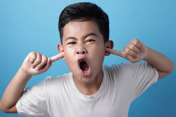 Азиатский мальчик кричит и закрывает уши, не хочу слышать — стоковое фото