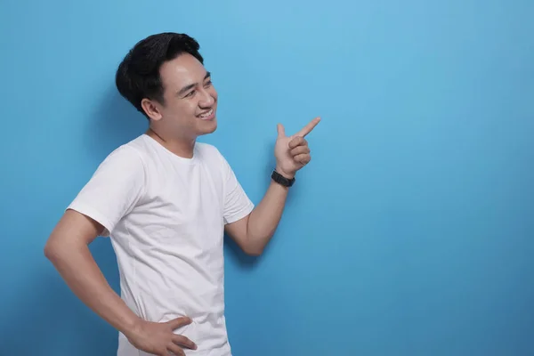 Boldog ázsiai fiatalember mutatva oldalra, bemutatva valamit fénymásoló hely — Stock Fotó