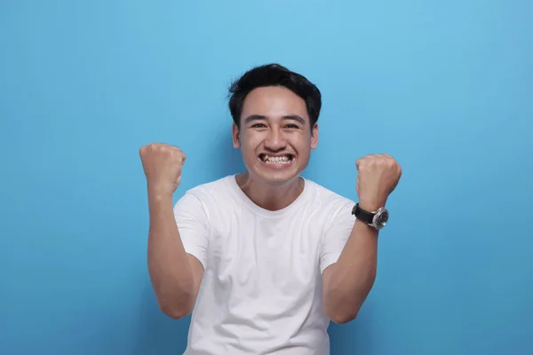 Happy Asian man shows winning gesture, celebrating victory — 스톡 사진