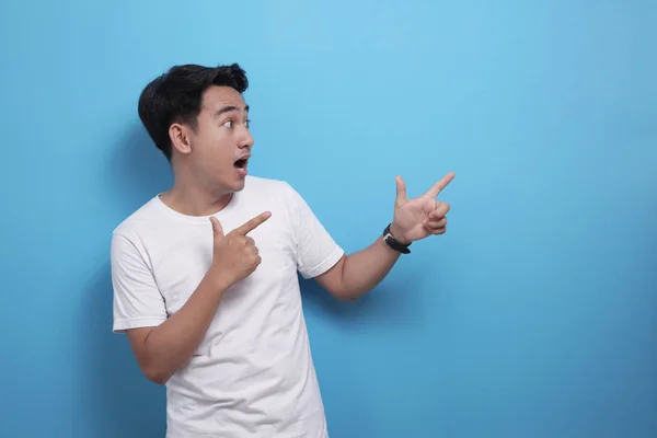 Happy Asian young man pointing to the side, presenting something with copy space — 스톡 사진