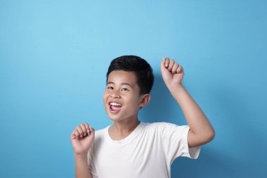 Mutlu başarılar Asyalı çocuk kazanan jest gösteriyor