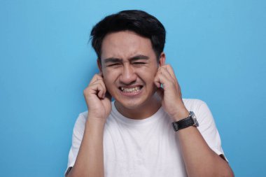 Genç adam kulaklarını kapattı. Kötü bir şey duymak istemiyor.