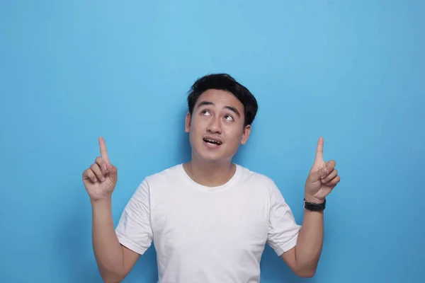 Joven sonriendo y señalando hacia arriba — Foto de Stock