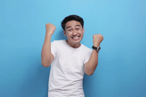Счастливый азиат показывает победный жест, празднуя победу — стоковое фото