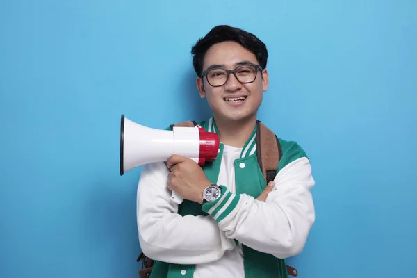 穿着绿色夹克衫，手持扩音器的自豪的亚洲年轻男生 — 图库照片